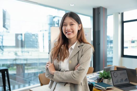 Portrait of successful business asian woman with arms crossed and smile , Young businesswoman smiling and looking at camera in meeting room, Happy feeling concept.