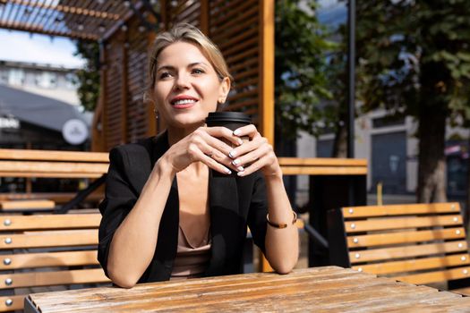 portrait of a successful business woman with a smile on her face in a street cafe with a cup of coffee.