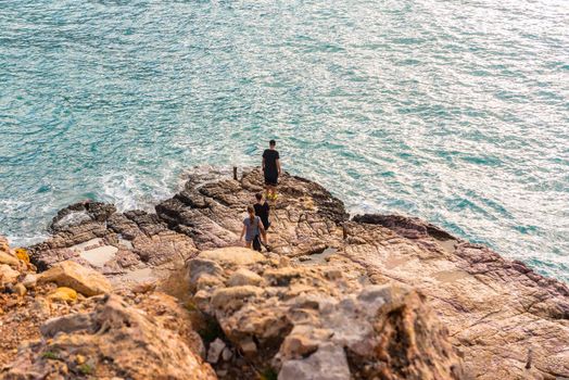 Cala Salada and Saladeta, Ibiza, Spain : 2019 November 04: 3 youngs stay in the rock in winter in Cala Salada in  San Antonio Abad at Balearic Islands Spain.