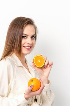 Young Caucasian smiling woman with slices orange over isolated white background