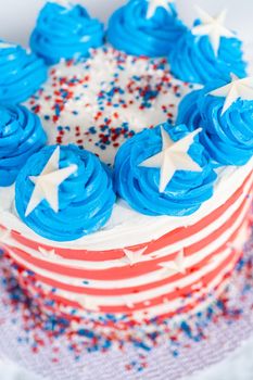 Decorating chocolate cake with white, red, and blue buttercream frosting for July 4th celebration.