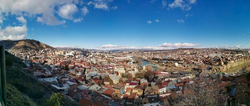 Panorama of Tbilisi. The capital of Georgia on a sunny day from a bird's eye view. Old city with buildings and river. Historic European city