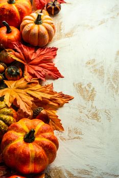 Autumnal flat lay with leaves and pumpkins on wooden background