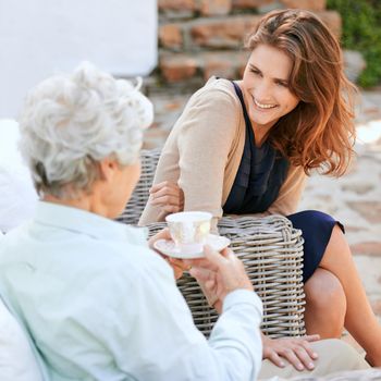 Theyre still so close...a young woman and her senior mother having tea outdoors