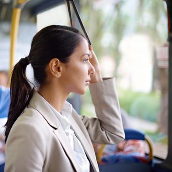 Beautiful businesswoman on the bus. a young businesswoman commuting to work