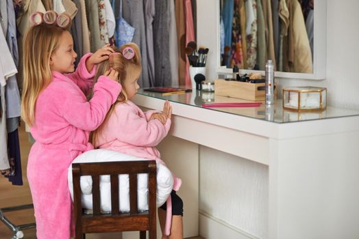 Pretending theyre at the beauty salon. two young sisters playing with moms makeup