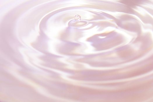 Beautiful pink-violet background in the form of circles on the water and a small drop of water. Universal abstract background.