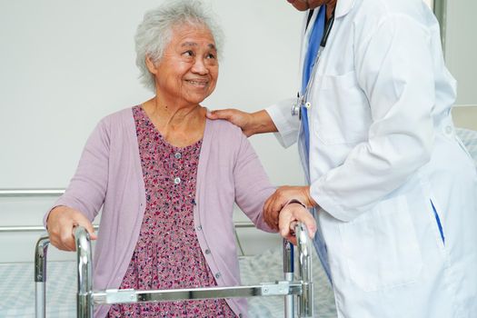 Asian elderly woman disability patient walk with walker in nursing hospital, medical concept.