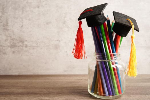 Graduation hat with colorful pencils on book with copy space, learning university education concept.