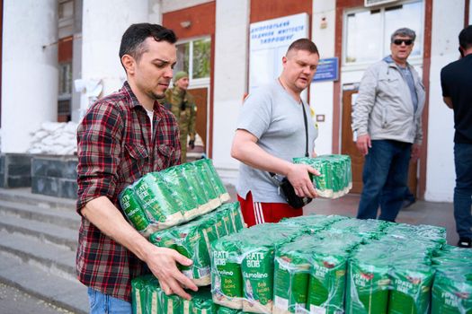 Ukrainian volunteers unloading boxes with humanitarian aid. Dnipro, Ukraine - 06.30.2022