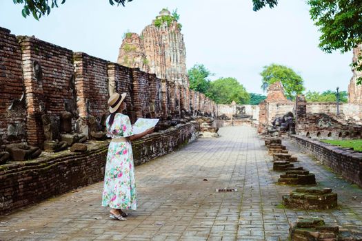 Ayutthaya, Thailand at Wat Mahathat, women with a hat and tourist maps visiting Ayyuthaya Thailand. Tourist with map in Thailand