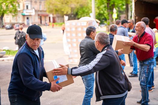 Ukrainian volunteers unloading boxes with humanitarian aid. Dnipro, Ukraine - 04.30.2022