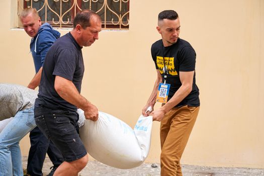 Ukrainian volunteers carry sack with groats. Dnipro, Ukraine - 06.30.2022