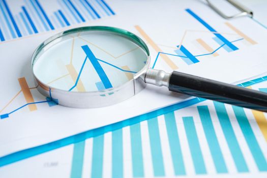 Magnifying glass on charts graphs paper. Financial development, Banking Account, Statistics, Investment Analytic research data economy.