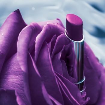Cosmetic branding, luxe and fashion concept - Purple lipstick and rose flower on liquid background, waterproof glamour make-up and lip gloss cosmetics product for luxury beauty brand holiday design