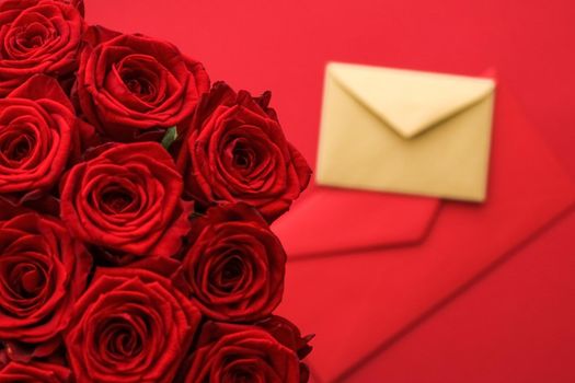 Holiday gift, flowers flatlay and happy relationship concept - Love letter and flower delivery service on Valentines Day, luxury bouquet of red roses and card envelopes on red background