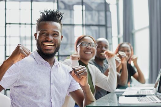 Happy young African-American man and his team in background