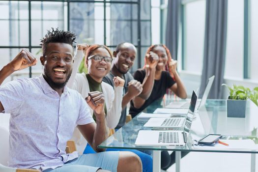 Happy young African-American man and his team in background