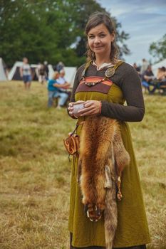 Hojbjerg, Denmark, August, 2022: Beautiful woman with fox skin at viking festival
