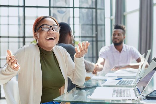 Portrait Of Businesswoman In Modern Open Plan Office With Business Team Working In Backgroun