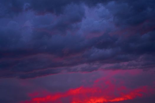 Fiery summer sunset landscape. Orange sun and dark blue sky.