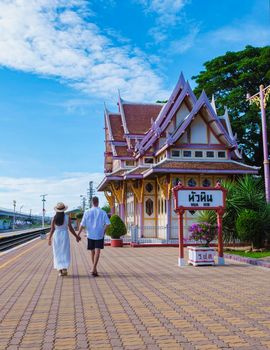 A couple of men and women are walking at Hua Hin train station in Thailand. Asian women and Caucasian men walking at the train station of Huahin