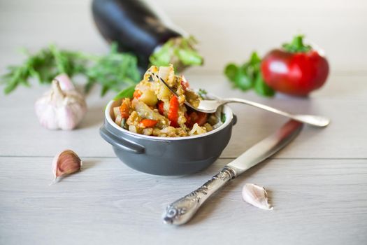 eggplant fried sauteed with other vegetables in a plate on a wooden table