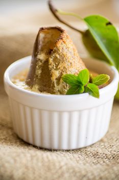 pear baked in curd dough in a small ceramic form, on burlap