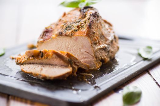 Baked sirloin turkey meat homemade with spices, on a wooden table.