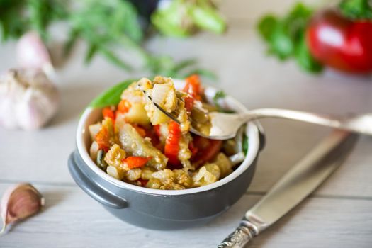 eggplant fried sauteed with other vegetables in a plate on a wooden table
