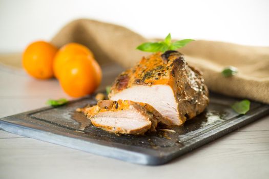 Baked sirloin turkey meat homemade with spices, on a wooden table.