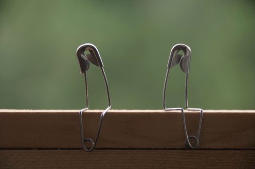 Safety pin couple sitting on table ignoring each other. Conflict and romance concept.
