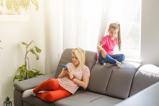 mother plays on the phone but does not play with her daughter