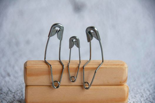 Model safety pin of parent and children sitting on wooden table with customizable space for text or ideas. Family concept.
