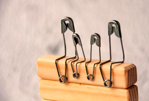 Model safety pin of family sitting on wooden blocks. Family concept.