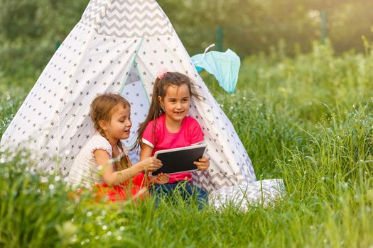 children playing in tablet pc in a tent