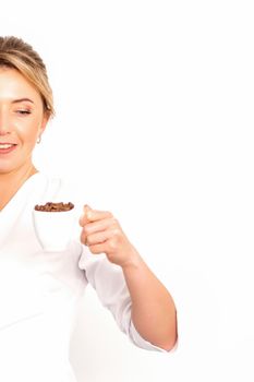 Cup of coffee beans. The female nutritionist holds a cup of coffee beans in her hand on white background