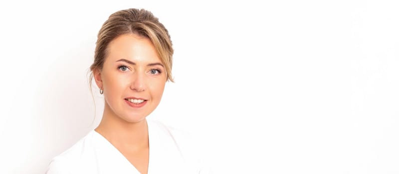 Close-up portrait of young smiling female caucasian healthcare worker standing staring at the camera on white background