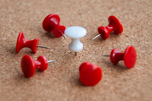 Red push pins targeting on white push pin. Harassment and discrimination concept