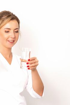 A glass of water. The female nutritionist holds a glass of water in her hand on white background