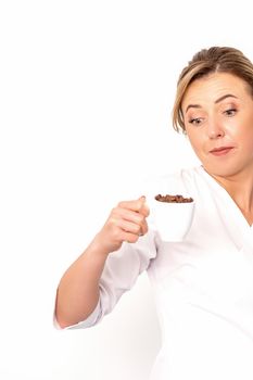Cup of coffee beans. The female nutritionist holds a cup of coffee beans in her hand on white background