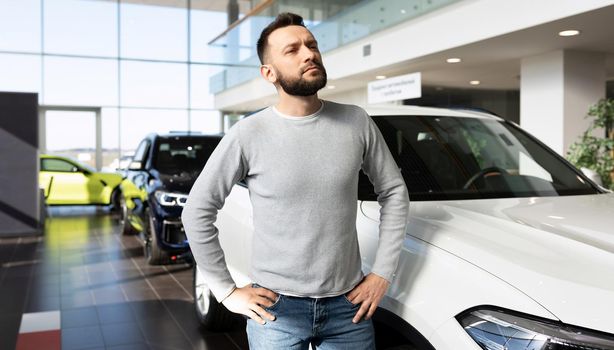 middle-aged man chooses a new car in a car dealership.