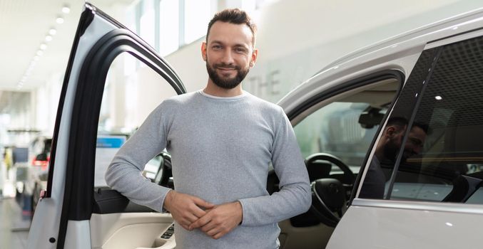 new car buyer happy in car showroom next to suv.