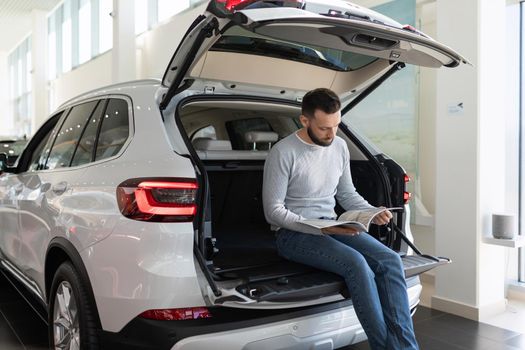 a family man in a car dealership draws up an insurance policy for a new purchased car.