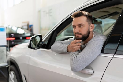 a man, when buying a new car in a car dealership, thought about an insurance policy for a driver from his family.
