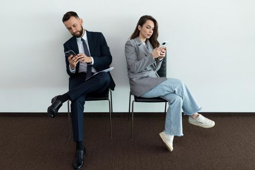 man and woman waiting in line job interview invitation.
