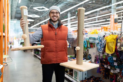 caring owner picks up a scratching post for his pet cat.