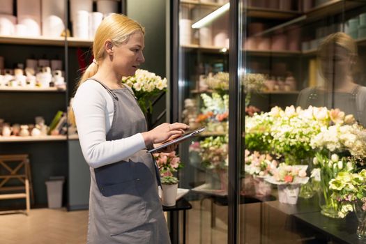 a florist in a flower shop does not inspect a window with bouquets and orders a new batch of flowers