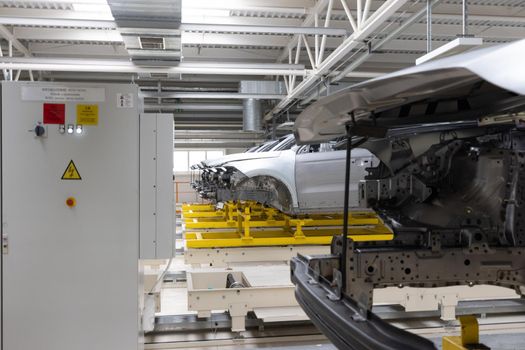 Car bodies are on assembly line. Factory for production of cars. Modern automotive industry. Plant concept.