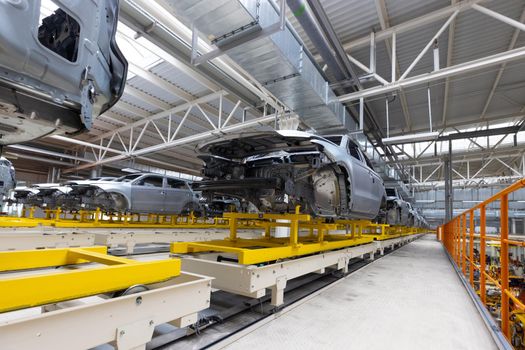 Car bodies are on assembly line. Factory for production of cars. Modern automotive industry.